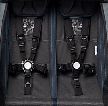 Black 5-point safety harnesses with white buckles in Croozer Kid Vaaya bike trailer for secure child transport